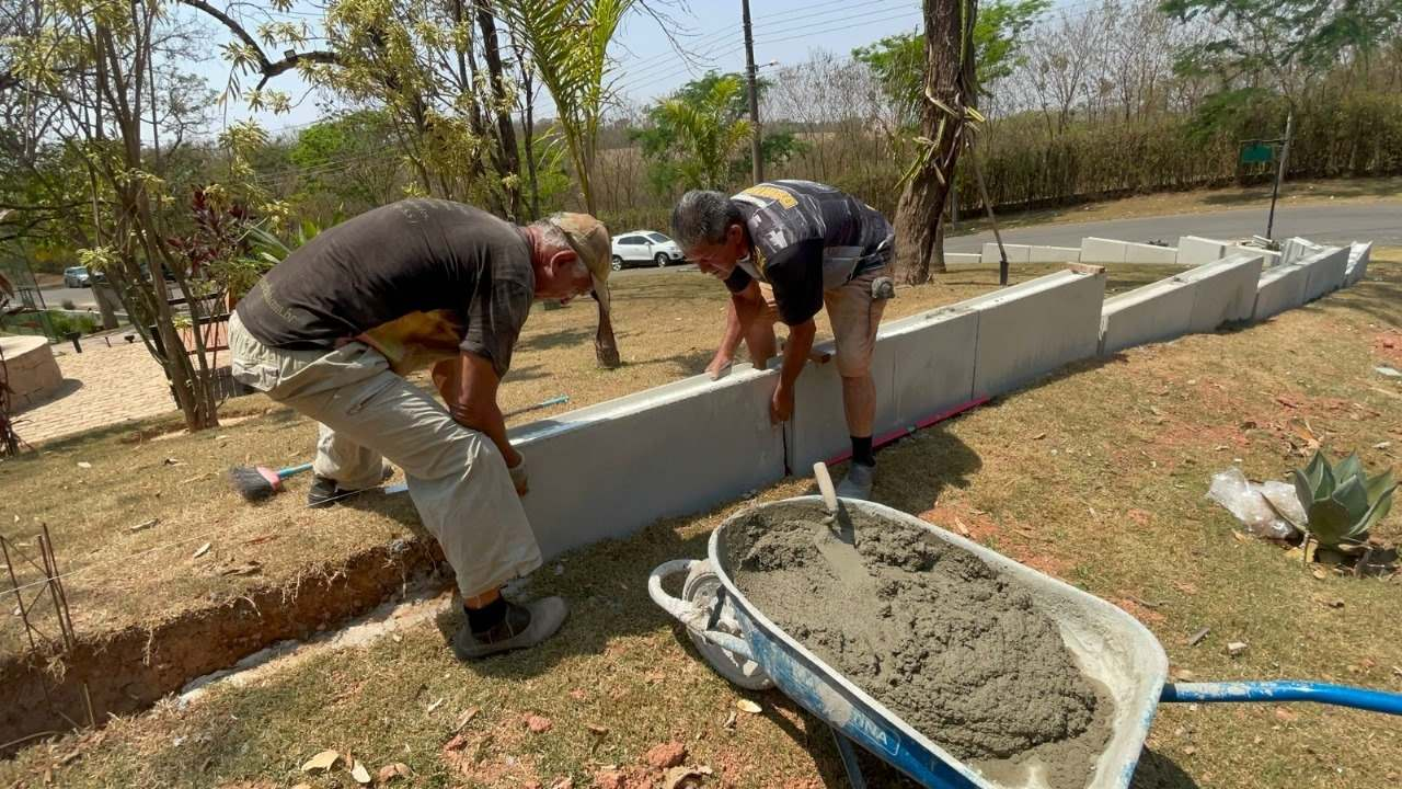 Equipe assentando painéis Inova Blocos em muro